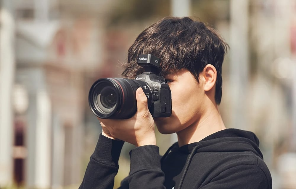 Fotograf korzystający z aparatu Canon EOS R6 Mark II i wyzwalacza Godox X3 C
